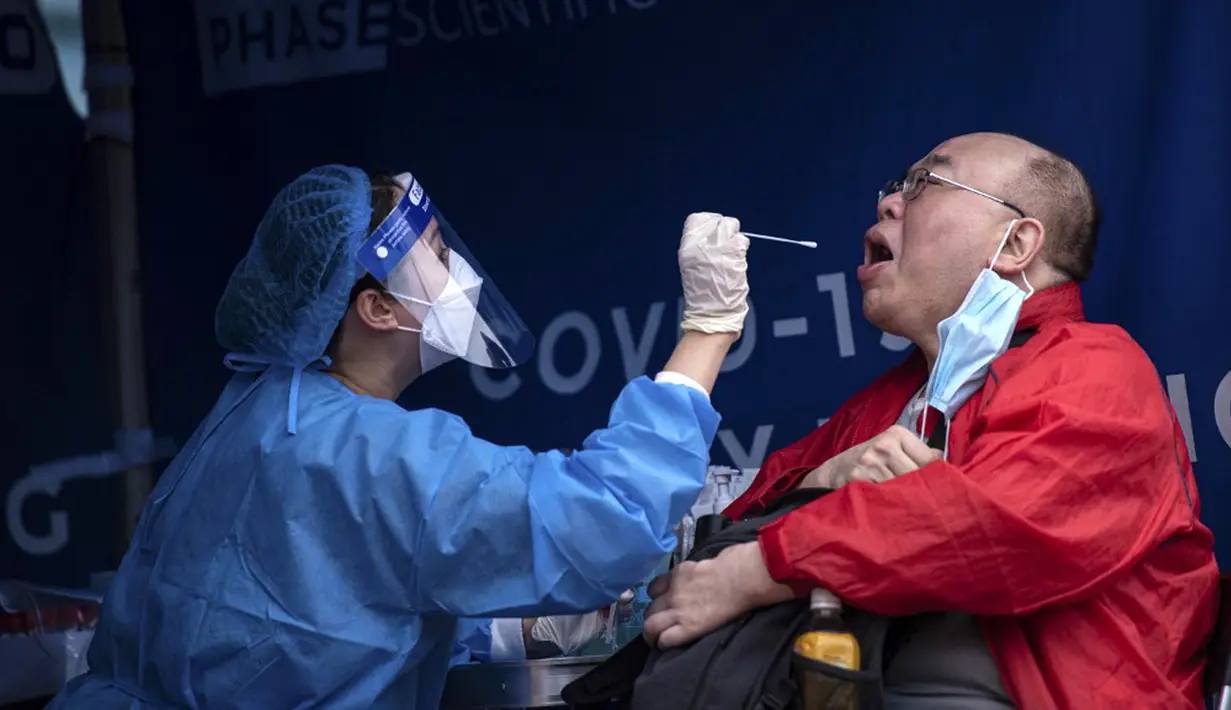 Seorang pria (kanan) melakukan pengujian virus corona COVID-19 di Hong Kong, 12 Februari 2022. Pihak berwenang bergegas untuk meningkatkan kapasitas pengujian COVID-19 menyusul rekor tertinggi infeksi baru. (Louise Delmotte/AFP)