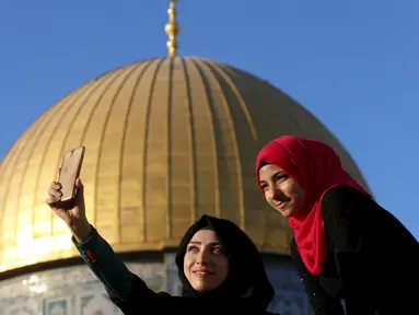 Salma Salame (kiri) dari kota Arab berfoto selfie dengan temannya di depan kubah Ash-Shakhrah di area Masjid Al-Aqsa, Yerusalem, 29 Juni 2015. (REUTERS/Ammar Awad)