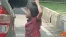 Citizen6, Bandung: Seorang anak sedang menawarkan cobeknya sambil mengemis ke pengendara mobil di lampu merah, Jl. Seram, Bandung