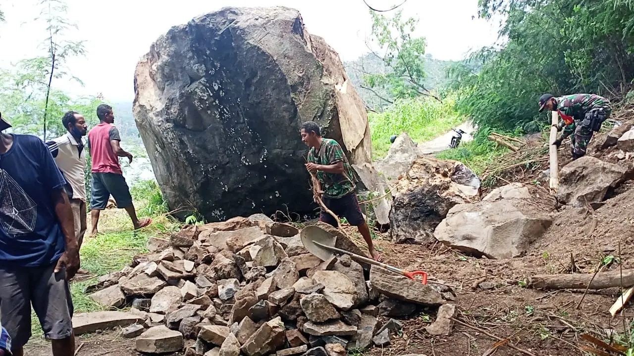Longsor batu besar tutup jalan, warga dan Babinsa gotong royong membuka akses jalan setapak dan pindahkan batu berukuran lebih kecil. (Liputan6.com/ Dionisius Wilibardus)