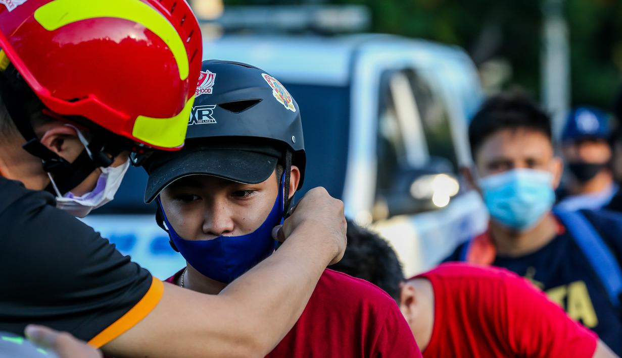 Seorang anggota lembaga swadaya masyarakat membagikan helm dan selempang reflektif secara gratis kepada pengendara sepeda di Manila, Filipina (9/7/2020). (Xinhua/Rouelle Umali)