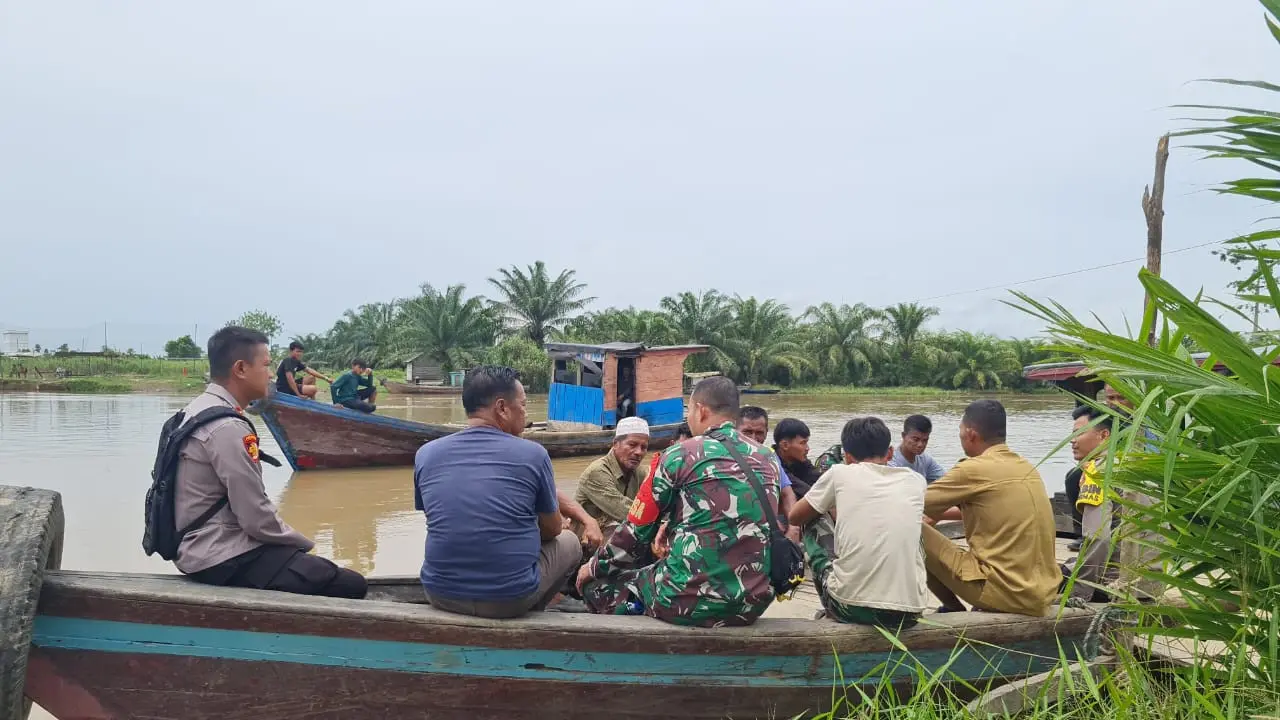 Kapolsek Bonai Darussalam, Rokan Hulu, berdialog dengan tokoh masyarakat dan warga di atas perahu membahas sosialisasi Pilkada.