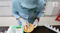 Tenaga farmasi meracik obat di RSIA Tambak, Jakarta, Jumat (21/10/2022). Penggunaan puyer memiliki beberapa kelebihan, seperti harga obat yang relatif lebih mudah dan mudah diberikan kepada anak. (Liputan6.com/Herman Zakharia)