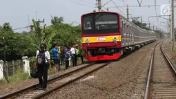 Sejumlah penumpang KRL Commuter Line terpaksa berjalan kaki menuju Stasiun Bojonggede, Bogor, Jawa Barat, Minggu (4/8/2019). Padamnya listrik di wilayah Jabodetabek mengakibatkan perjalanan KRL Commuter Line terhenti. (Liputan6.com/Helmi Fithriansyah)
