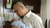 Ahmad Dhani meggendong anak keduanya dari Mulan Jameela, Ahmad Syailendra Aerlangga [foto: instagram/realmulanjamela]