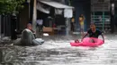 Sejumlah anak bermain saat banjir menggenangi kawasan Pasar Buncit, Jakarta Selatan, Selasa (9/2/2016). Banjir menggenangi kawasan tersebut hingga setinggi 100 cm akibat luapan Kali Kemang. (Liputan6.com/Gempur M Surya)