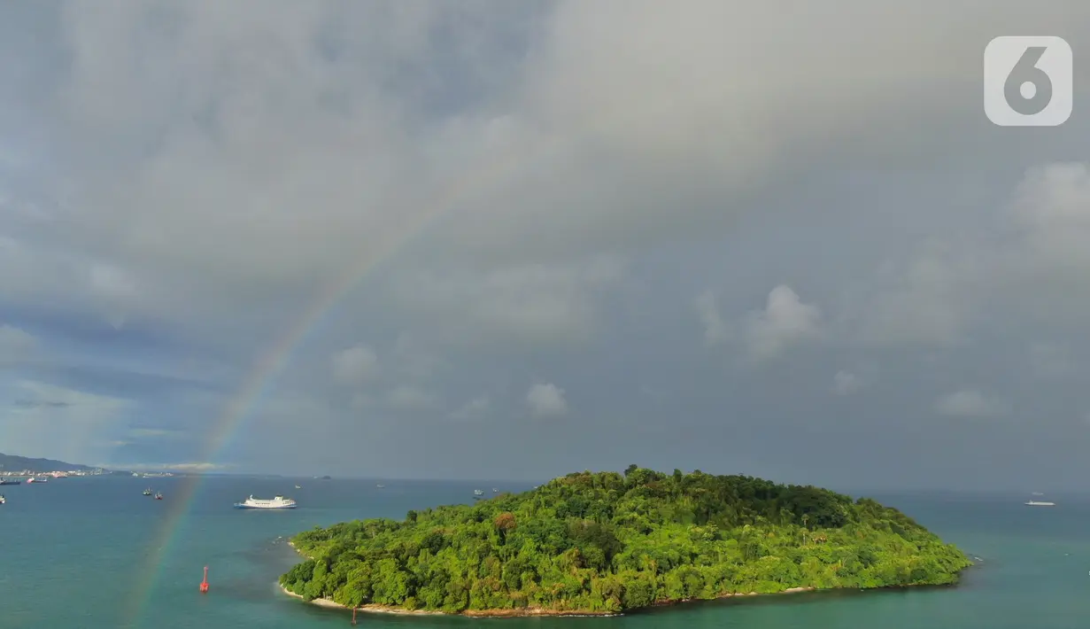 <p>Keindahan pelangi saat menghiasi langit Pelabuhan Merak, Banten, Sabtu (30/4/2022). Kemunculan pelangi tersebut menjadi pemandangan yang indah bagi para pemudik yang ingin menyebrang ke pulau Sumatra. (Liputan6.com/Angga Yuniar)</p>