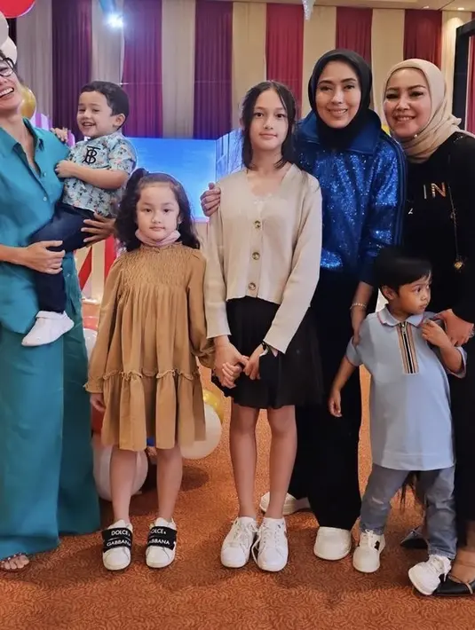 Ussy hadir mengenakan two pieces warna biru dari kemeja hingga celananya dan membawa ketiga anaknya.  (@ussypratama)