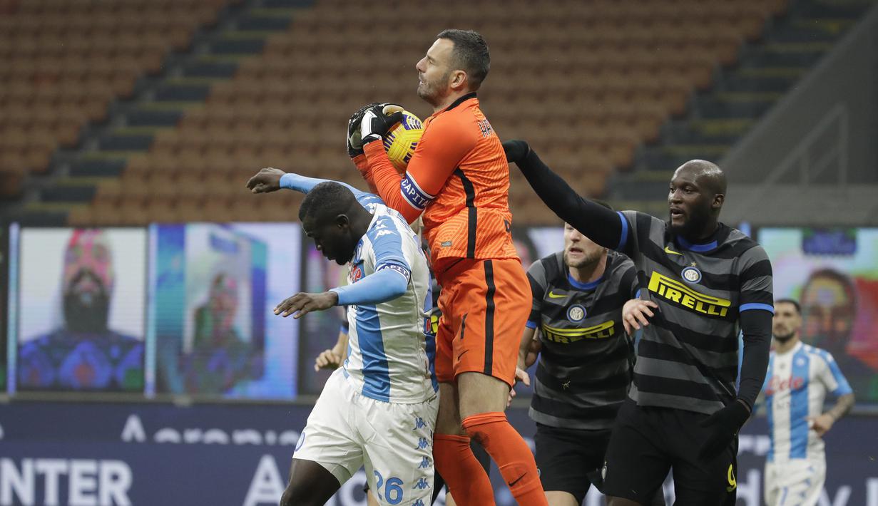 Kiper Inter Milan, Samir Handanovic (tengah), menangkap bola dari ancaman bek Napoli, Kalidou Koulibaly (kiri), dalam laga lanjutan Liga Italia 2020/21 Serie A pekan ke-12 di San Siro Stadium, Rabu (16/12/2020). Inter menang 1-0 atas Napoli. (AP/Luca Bruno)