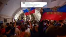 Suporter Rusia berpesta merayakan keberhasilan negaranya mengalahkan Spanyol pada laga 16 besar Piala Dunia di Moskow, Minggu (1/7/2018). Rusia untuk pertama kalinya lolos ke babak perempatfinal. (AFP/Yuri Kadobnov)