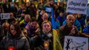 Orang-orang Ukraina mengambil bagian dalam protes yang menandai satu tahun sejak invasi Rusia ke Ukraina di Alun-Alun Spanyol di Madrid, Spanyol, 24 Februari 2023. Spanduk itu bertuliskan dalam bahasa Spanyol: "Berhenti membunuh kami". (AP Photo/Manu Fernandez)