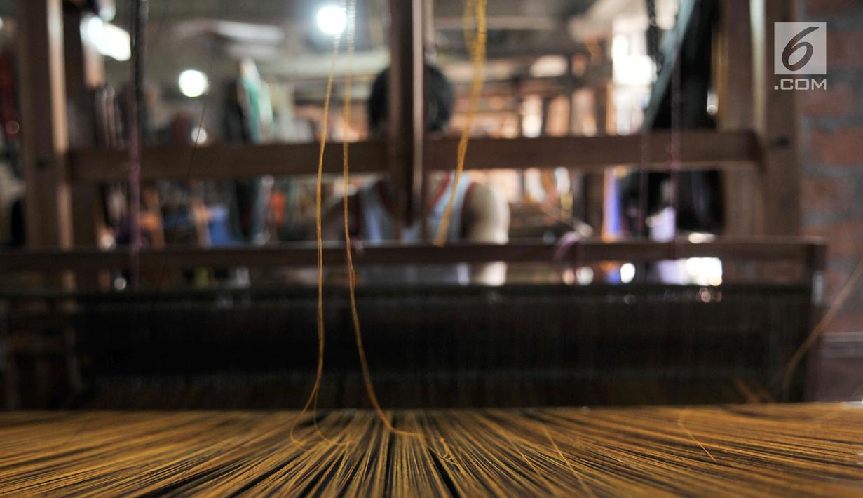 Pengrajin saat menyelesaikan pembuatan tenun ikat di salah satu industri rumahan di Desa Bandar Kidul, Kediri, Jawa Timur, Sabtu (29/9). Industri tenun ikat Kediri sudah ada sejak zaman kolonial Belanda. (Merdeka.com/Iqbal Nugroho)