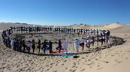 Peserta menghadiri kelas yoga yang diselenggarakan oleh komunitas YSYoga System di gurun Samalayuca, negara bagian Chihuahua, Meksiko pada 25 Mei 2019. Latihan di atas pasir gurun yang terik ini menjadi tantangan tersendiri bagi para pencinta Yoga. (Herika MARTINEZ/AFP)