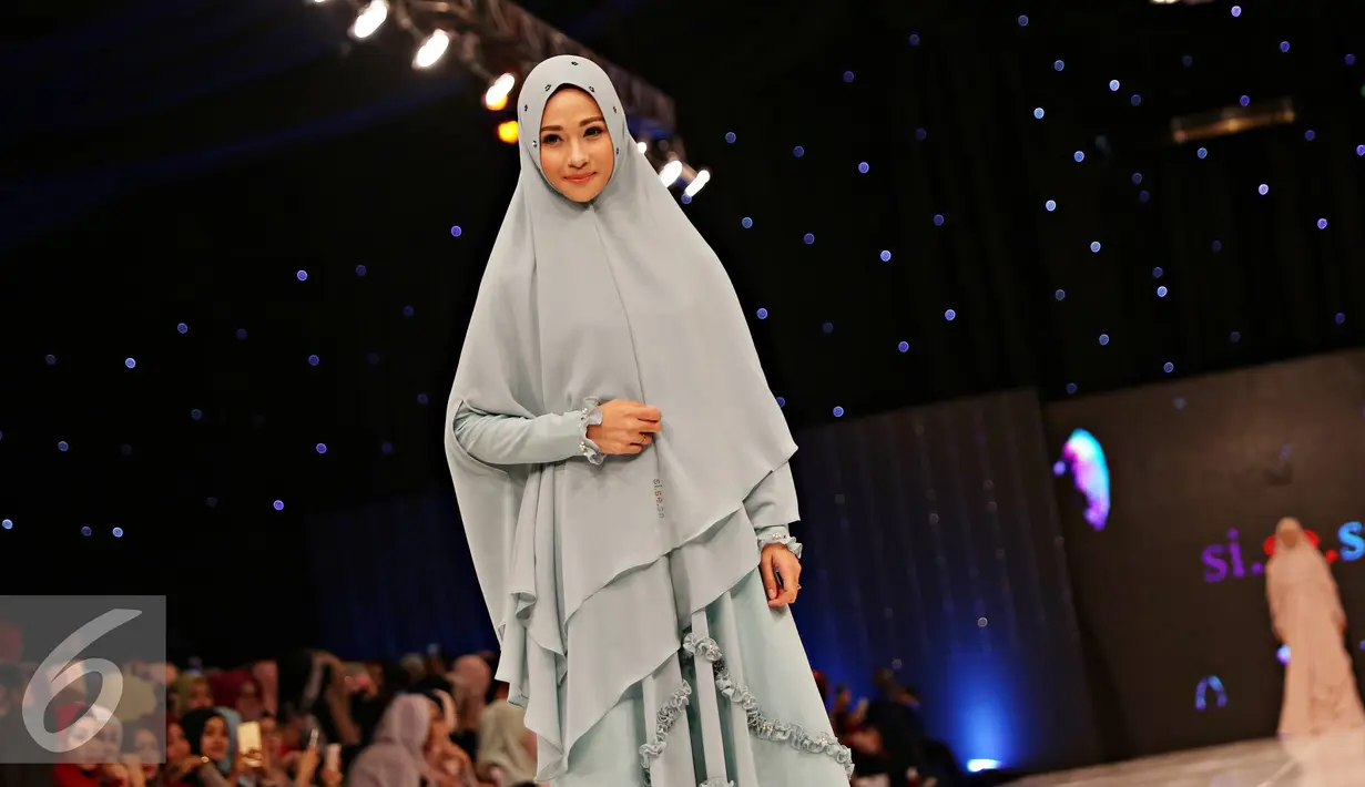 Artis Bunga Poppy membawakan busana muslim rancangan Si.Se.Sa: Syar'i for Urban, Jakarta (10/2). Peragaan menampilkan 61 koleksi dalam tujuh rangkaian babak produk terbaru Si.Se.Sa dengan rentang warna pastel yang lebar. (Liputan6.com/Immanuel Antonius)
