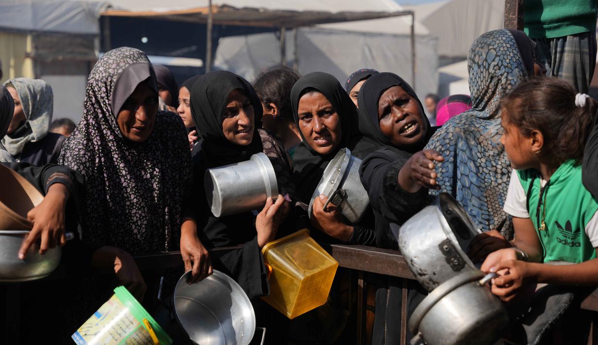 Warga Palestina menunggu bantuan gula dan beras di dapur umum di Khan Younis, Jalur Gaza selatan, Jumat, 31 Oktober 2025. Setiap harinya, ratusan warga, termasuk wanita, anak-anak, dan lansia, terlihat mengantre panjang di dapur umum dan dapur amal yang ada. (AP Photo/Abdel Kareem Hana)