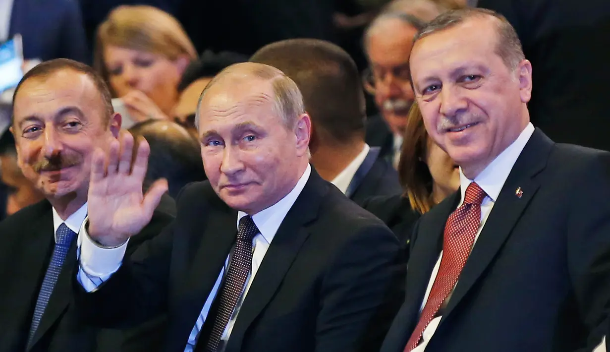 Presiden Rusia Vladimir Putin bersama Presiden Turki Recep Tayyip Erdogan tersenyum kepada awak media Putin saat menghadiri 23rd World Energy Conress, Istanbul, Turki (10/10). (AP Photo/Emrah Gurel)
