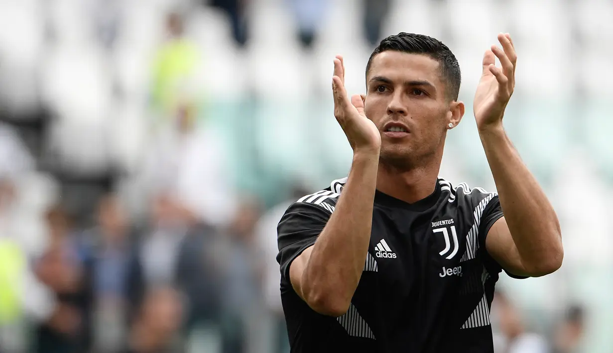 Pesepak bola Cristiano Ronaldo bertepuk tangan saat pemanasan di Stadion Allianz, Turin, Italia, 25 Agustus 2018. Ronaldo masuk dalam daftar 100 pria tertampan di dunia bersaing dengan pebulu tangkis Indonesia, Jonatan Christie. (Filippo MONTEFORTE/AFP)