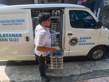 Petugas mendistribusikan ompremg makan bergizi gratis (MBG)  di Posyandu kawasan Limo, Depok, Jawa Barat, Selasa (14/7/2025).