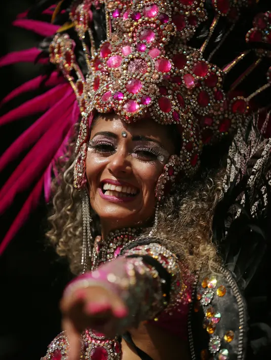Ekspresi seorang wanita yang mengenakan kostum saat menari dalam Karnaval Notting Hill di London (28/8). Karnaval ini merupakan satu perayaan terbesar di Eropa. (AP Photo / Tim Irlandia)