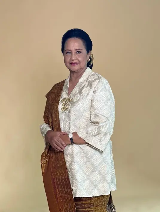 Simpel tapi elegan, Devi mengenakan kebaya putih dengan detail tekstur emboss. Kebaya tersebut dipadukannya dengan selendang dan bawahan dari songket. [@pandjaitandevi]
