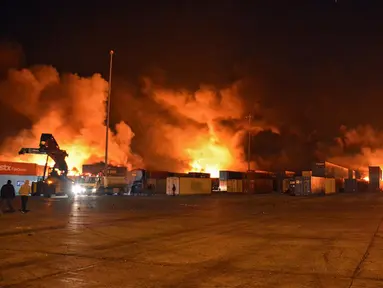 Petugas pemadam kebakaran berjuang melawan kobaran api setelah serangan udara Israel di Pelabuhan Latakia, Suriah, 28 Desember 2021. Serangan udara Israel menghantam Pelabuhan Latakia sekitar pukul 03.21 waktu setempat. (SANA/AFP)