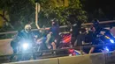 Demonstran dijemput menggunakan sepeda motor setelah menuruni jembatan menggunakan tali untuk melarikan diri dari Universitas Politeknik Hong Kong di Distrik Hung Hom, Hong Kong, Senin (18/11/2019). Lusinan demonstran berhasil melarikan diri dari kepungan polisi. (ANTHONY WALLACE/AFP)