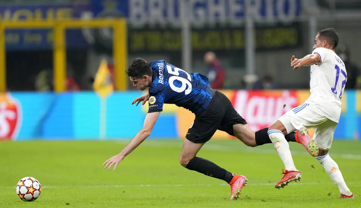 Pemain Inter Milan Alessandro Bastoni (kiri) berebut bola dengan pemain Real Madrid Lucas Vazquez pada pertandingan Grup D Liga Champions di Stadion San Siro, Milan, Italia, Rabu (15/9/2021). Real Madrid menang 1-0. (AP Photo/Antonio Calanni)