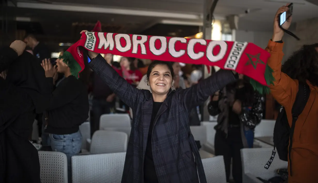 Warga Maroko merayakan kemenangan negaranya atas Portugal pada babak 8 besar Piala Dunia 2022, di ibu kota Rabat, Sabtu (10/12/2022). Maroko mengubur mimpi Cristiano Ronaldo lewat gol semata wayang yang diciptakan Youssef En-Nesyri di babak pertama. (AP Photo/Mosa'ab Elshamy)
