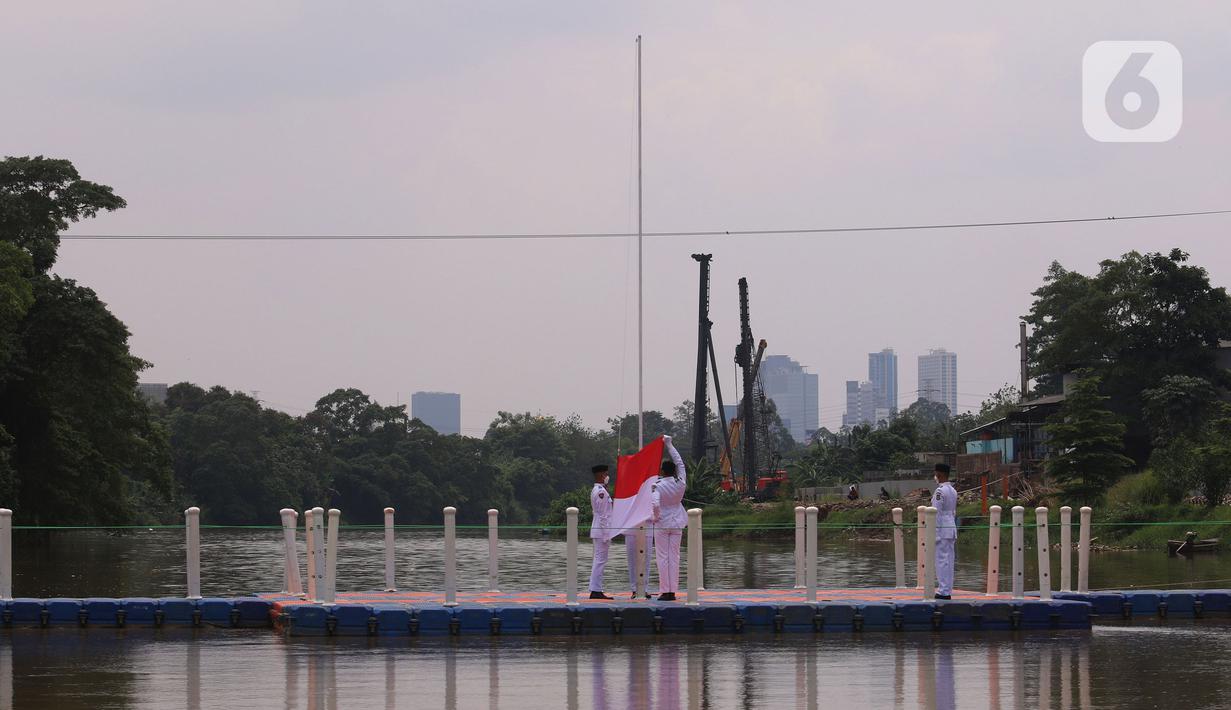 Anggota Paskibraka melakukan pengibaran bendera merah putih di Sungai Cisadane, Kota Tangerang, Banten, Kamis (28/10/2021). Pengibaran bendera merah putih yang di ikuti puluhan pemuda tersebut di lakukan untuk memperingati hari sumpah pemuda. (Liputan6.com/Angga Yuniar)