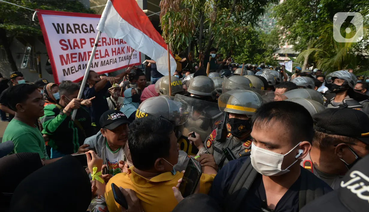 Polisi terlibat saling dorong dengan warga saat melakukan eksekusi lahan rumah warga Kelurahan Pulogebang RT 20 RW 06 (dahulu RT 08/RW 06) di Jakarta, Selasa (8/6/2021). Eksekusi lahan tersebut berakhir ricuh. (merdeka.com/Imam Buhori)
