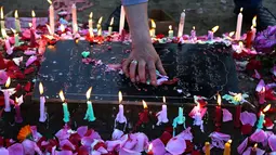 Lilin dan taburan bunga di pemakaman saat memperingati Shab-e-Barat di pinggiran Srinagar, Kashmir (11/5). Shab-e-Barat atau Nisfu Sya'ban adalah peringatan pada tanggal 15 bulan kedelapan (Sya'ban) dari kalender Islam. (AP Photo / Mukhtar Khan)