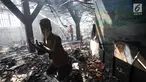 Pemadam kebakaran melakukan pendinginan pascaterbakarnya Museum Bahari di Jalan Pasar Ikan, Penjaringan, Jakarta Utara, Selasa (16/1). Sebuah patung terlihat masih tetap terjaga meski sekelilingnya ludes terbakar. (Liputan6.com/Arya Manggala)