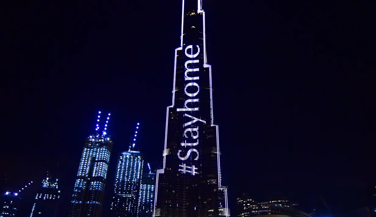 Pencakar langit Burj Khalifa menyala dengan pesan "Stay Home" di Dubai pada Selasa (24/3/2020). Gedung pencakar langit tertinggi di dunia itu menyala dengan slogan kampanye #STAYHOME yang mendesak warga untuk mematuhi langkah-langkah pencegahan di tengah pandemi COVID-19. (Giuseppe CACACE/AFP)