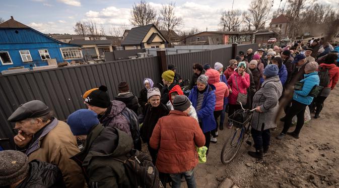Warga menunggu makanan di luar sebuah gereja di timur laut kota Trostianets (29/3/2022). Ukraina mengatakan pasukannya telah merebut kembali kota Trostianets, dekat perbatasan Rusia, salah satu kota pertama yang jatuh di bawah Kontrol Moskow dalam invasi selama sebulan. (AFP/Fadel Senna)