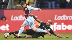 Aksi bek Manchester City, Vincent Kompany (kanan) menghalau bola dari kaki pemain Burnley, Berg Gudmundsson (kiri) pada lanjutan Premier League di Turf Moor  Stadium, Burnley, (3/2/2018). Burnley tahan Manchester City 1-1. (AFP/Oli Scarff)