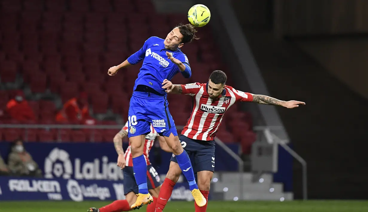 Bek Atletico Madrid, Mario Hermoso, duel udara dengan pemain Getafe, Enes Unal, pada laga Liga Spanyol di Stadion Wanda Metropolitano, Rabu (30/12/2020). Atletico Madrid menang dengan skor 1-0. (AFP/Oscar Del Pozo)