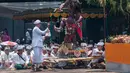 Pemangku menyipratkan air suci pada patung ogoh-ogoh dalam prosesi Tawur Agung Kesanga di Pura Aditya Jaya, Jakarta, Senin (27/3). Kegiatan Tawur Agung Kesanga merupakan salah satu dari empat ritual utama perayaan Nyepi. (Liputan6.com/Gempur M Surya)