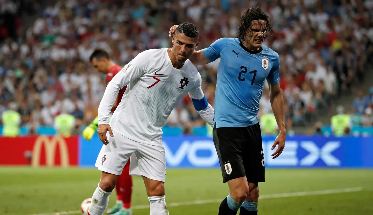 Penyerang Portugal, Cristiano Ronaldo membantu Penyerang Uruguay, Edinson Cavani yang Cedera keluar lapangan saat pertandingan babak 16 besar Piala Dunia 2018 di Stadion Fisht di Sochi, Rusia (30/6).  (AP Photo/Francisco Seco)