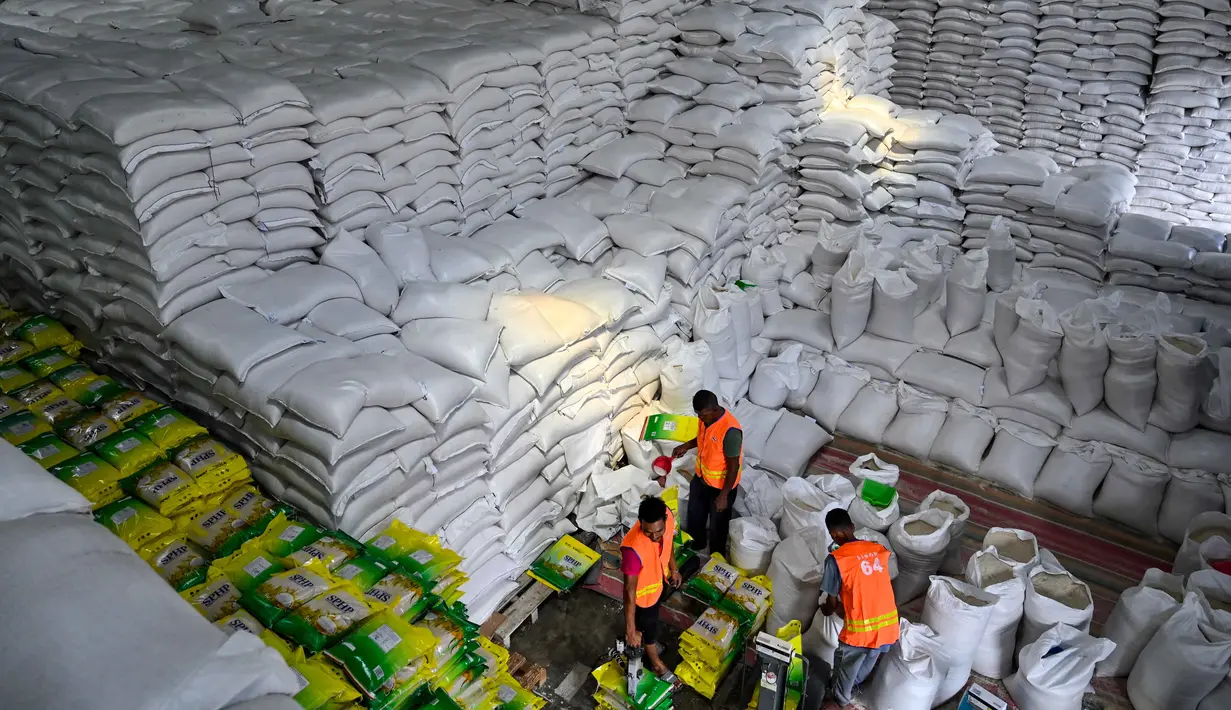 Saat ini, persediaan beras Bulog di Provinsi Aceh mencapai sekitar 97 ribu ton. Tampak dalam foto, para pekerja menyortir karung-karung beras di gudang Badan Urusan Logistik (Bulog) di Lambaro, Provinsi Aceh pada 29 Desember 2025. (CHAIDEER MAHYUDDIN/AFP)