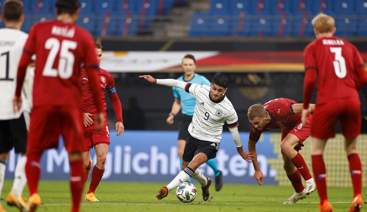 Gelandang Jerman, Mahmoud Dahoud dan gelandang Republik Ceko, Tomas Soucek berebut bola dalam laga persahabatan di Red Bull Arena, Leipzig, Kamis (12/11/2020) dini hari WIB. Jerman sukses mengalahkan Republik Ceko dengan skor tipis 1-0. (Odd ANDERSEN / AFP)