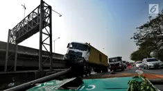 Kendaraan berat kontainer menabrak jalur pembatas pintu masuk tol akses Tanjung Priok di Jalan Raya Cilincing, Jakarta Utara, Sabtu (17/8/2019). Kejadian pada pukul 03.00 dini hari tadi terjadi akibat sopir mengantuk. Tidak ada korban jiwa dalam kejadian ini. (merdeka.com/Arie Basuki)