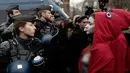 Polisi antihuru-hara menghadang aktivis wanita bertelanjang dada saat aksi protes rompi kuning di Paris, Prancis, Sabtu (15/12). Pengunjuk rasa keberatan dengan kenaikan pajak bahan bakar yang diusulkan pemerintah. (AP Photo/Kamil Zihnioglu)
