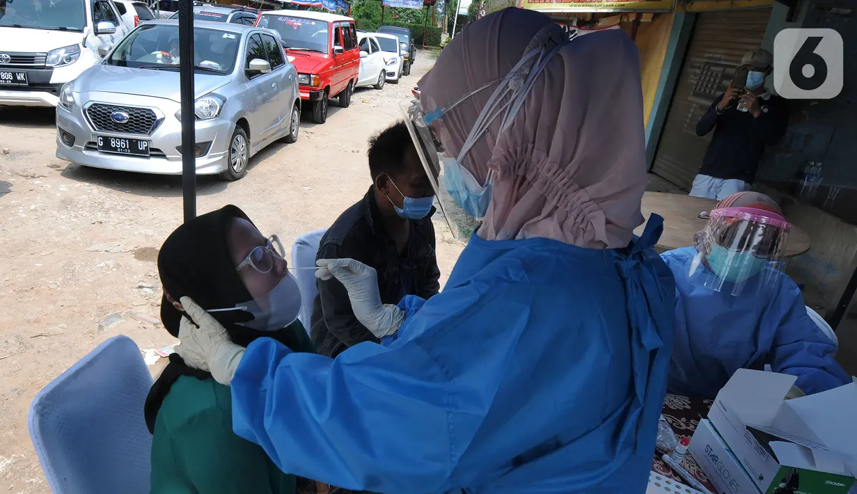 Paramedis melakukan swab antigen kepada pemudik di perbatasan Depok-Bogor, Jalan Raya Parung-Ciputat, Depok, Jawa Barat, Minggu (16/5/2021). Mulai hari ini, diberlakukan swab antigen kepada para pemudik yang akan kembali ke wilayah Depok. (merdeka.com/Arie Basuki)