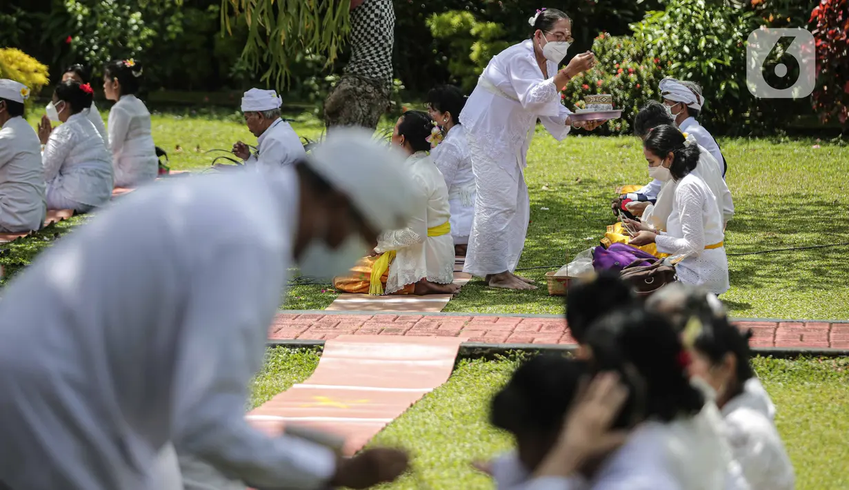 Umat Hindu menerima air suci saat upacara Tawur Agung Kesanga di Pura Amerta Jati, Cinere, Depok, Rabu (2/3/2022).  Upacara Tawur Agung Kesanga tersebut tahun ini hanya diikuti pemuka umat Hindu dan perwakilan dari pura sekitar dengan jumlah terbatas. (Liputan6.com/Faizal Fanani)