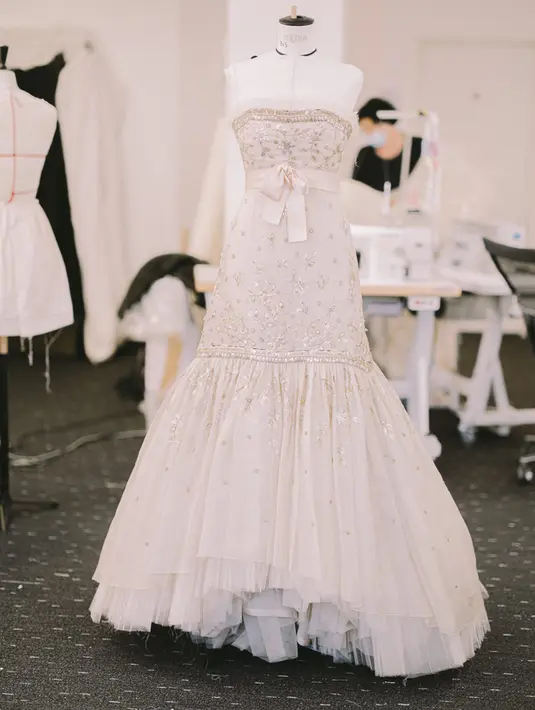 Gaun tanpa tali ini memiliki garis leher yang lurus dengan kerut tulle lipit yang halus dan dekorasi berupa sabuk satun appliqued dengan pita di bagian depan, rok, dan beberapa lipatan tulle pada rok organza. Foto: Document/Chanel.