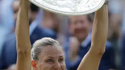 Petenis Jerman, Angelique Kerber tersenyum sambil mengangkat trofi usai mengalahkan petenis AS, Serena Williams pada final tunggal putri kejuaraan Tenis Wimbledon 2018 di London, (14/7). Kerber menang atas Williams 6-3,6-3. (AP Photo/Ben Curtis)