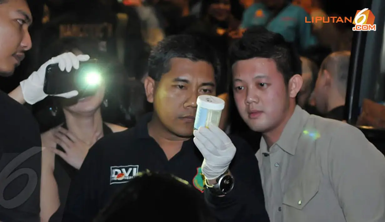 Petugas sedang mengamati hasil tes urine salah satu pengunjung dalam razia narkoba (Liputan6.com/Herman Zakharia).
