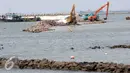 Sejumlah alat berat melakukan penimbunan material padat di Teluk Utara Jakarta, Rabu (16/3). Meskipun menuai pro dan kontra, proyek tersebut terus berjalan dan rencananya akan rampung pada akhir tahun 2018. (Liputan6.com/Helmi Afandi)