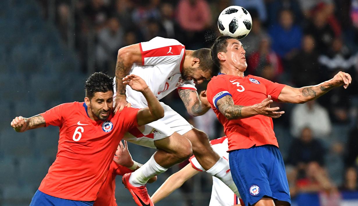 Aksi pemain Serbia, Aleksandar Mitrovic (tengah) saat duel dengan dua apemain Chili pada laga uji coba di Merkur Arena, Graz, Austria, (4/6/2018).  Serbia kalah dari Chili 0-1. (AFP/Joe Klamar)
