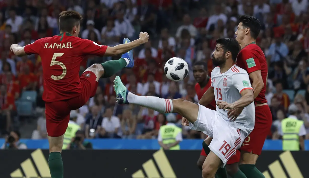 Striker Spanyol, Diego Costa, berebut bola dengan bek Portugal, Raphael Guerreiro, pada laga Grup B Piala Dunia di Stadion Fisht, Sochi, Jumat (15/6/2018). Kedua negara bermain imbang 3-3. (AP/Manu Fernandez)
